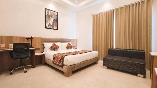 1 dormitorio con cama, escritorio y silla en Blessings Hotel en Amritsar