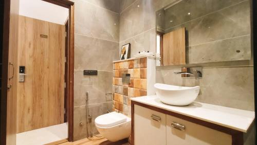 La salle de bains est pourvue de toilettes, d'un lavabo et d'une douche. dans l'établissement Blessings Hotel, à Amritsar
