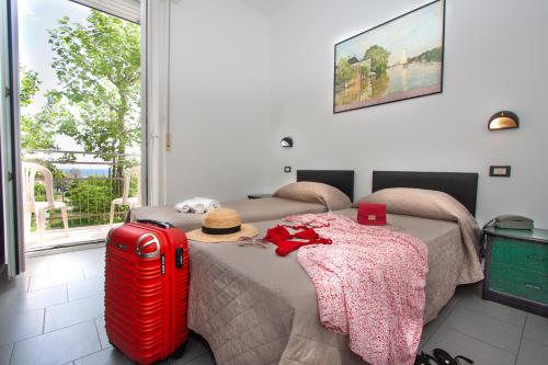 ein Bett mit einem Koffer und einem Hut darauf in der Unterkunft Hotel La Torretta Bramante in Rimini