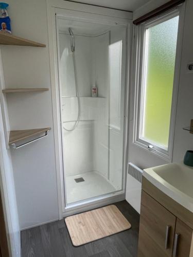 une douche en verre dans une cuisine avec une fenêtre dans l'établissement Joli Mobil home Camping 4 Le Bois Masson A34, à Saint-Jean-de-Monts