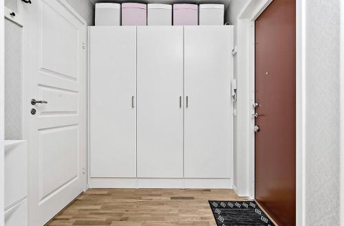 Habitación con armarios blancos y puerta. en DreamHouse en Sollentuna