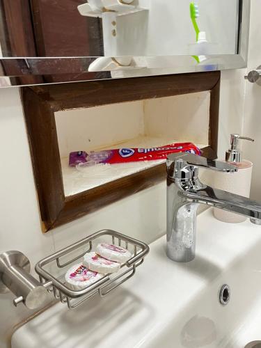 um suporte de escova de dentes num lavatório ao lado de um espelho em شقة مريحة فاخرة Cozy apartment, luxury with fun em Jidá