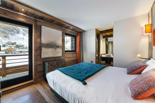 une chambre avec un lit et une grande fenêtre dans l'établissement Appartement Sifflote - LES CHALETS COVAREL, à La Daille