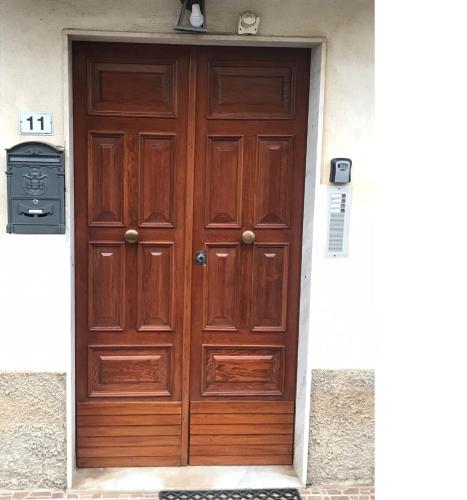 a large wooden door in a white building at Residenza delle Rose in Lamezia Terme