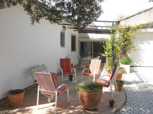 un groupe de chaises assises sur une terrasse dans l'établissement Maison familiale avec piscine et grand jardin, à Mornas