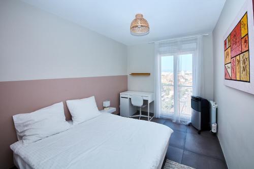 une chambre avec un lit blanc et une fenêtre dans l'établissement Logement entier vue mer T3 - plages 15 mn 9ème, à Marseille