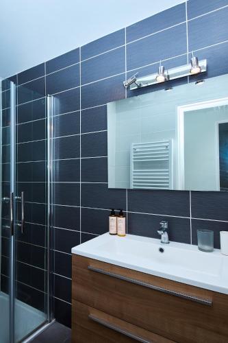 une salle de bain avec un lavabo, une douche et un miroir dans l'établissement Logement entier vue mer T3 - plages 15 mn 9ème, à Marseille