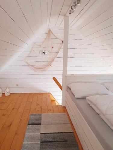 a attic room with a bed and a rug at Ferienhaus Svensson Altheide in Altheide