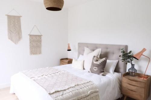 a white bedroom with a bed with white sheets and pillows at Villa La Foret Du Lac à HOSSEGOR in Soorts-Hossegor