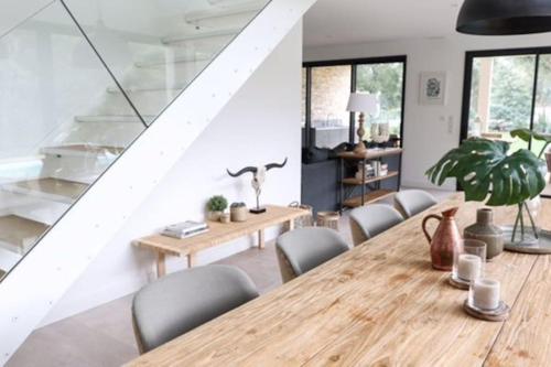 a dining room with a wooden table and chairs at Villa La Foret Du Lac à HOSSEGOR in Soorts-Hossegor