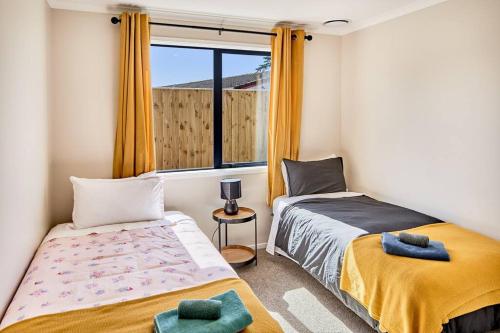 a bedroom with two beds and a window at Tranquility on the Hill Outdoor Bath 30 mins to city by train or car in Wellington