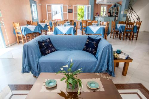 - un canapé bleu dans une pièce avec des tables et des chaises dans l'établissement Hotel Argo, à Galaxidi