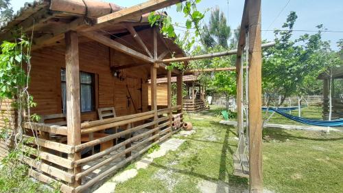 een houten hut met een hangmat buiten bij Tiny houses Genacvale in Martvili