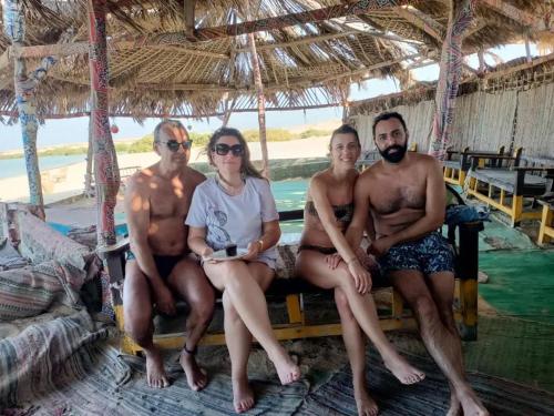 un grupo de personas sentadas en un banco en la playa en La Casa Budget, en Marsa Alam