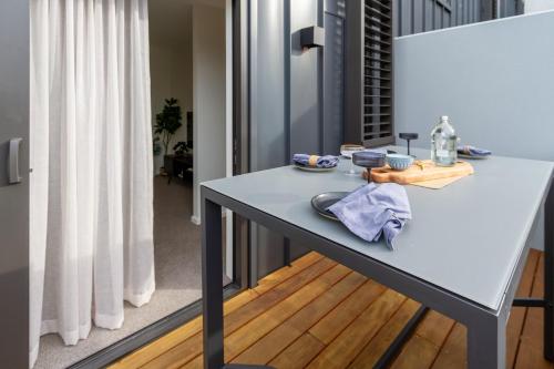 Relaxing City Hideaway - 2 Bed in Christchurch CBD في كرايستشيرش: طاولة بيضاء في غرفة ذات ستارة بيضاء
