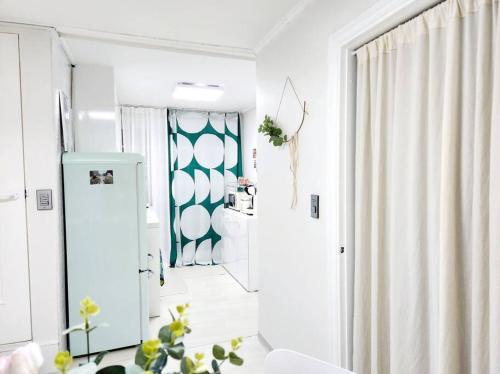 La salle de bains blanche est pourvue de toilettes et d'un miroir. dans l'établissement Near Mangwon Market, 5mins to Hongdae Station by car, à Séoul