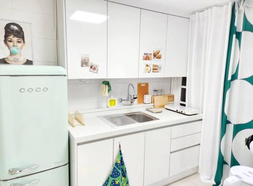 a small kitchen with white cabinets and a sink at Near Mangwon Market, 5mins to Hongdae Station by car in Seoul