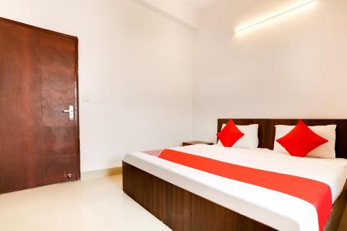 Flagship Agniv Residency في نيودلهي: غرفة نوم بسرير كبير ومخدات حمراء