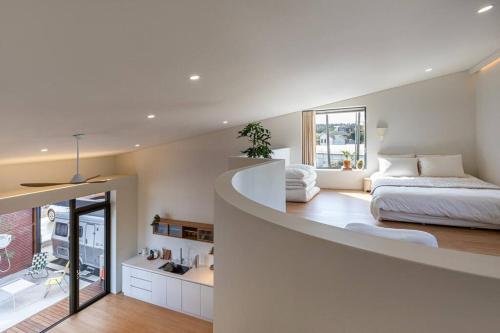 ein großes weißes Zimmer mit einem Bett und einem Bett und einem Zimmer in der Unterkunft Jeju Green Stay Nuguhana in Jeju-do