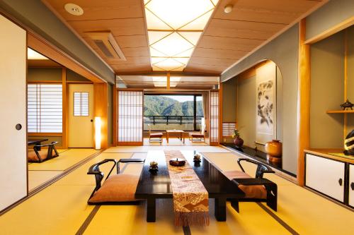 a large living room with a table and chairs at Kawaguchiya Kinosaki Riverside Hotel in Toyooka