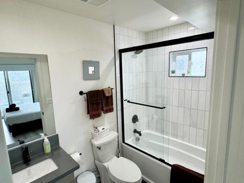 a bathroom with a shower and a toilet and a sink at Cozy Chamber 3 BR Hollywood Townhouse in Los Angeles
