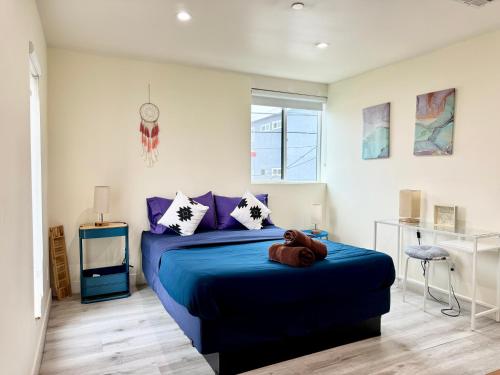 a bedroom with a blue bed with purple pillows at Cozy Chamber 3 BR Hollywood Townhouse in Los Angeles