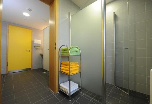 a bathroom with a shower and a rack with towels at Bildungs- uns Tagungshäuser Vierzehnheiligen Diözesanhaus in Bad Staffelstein