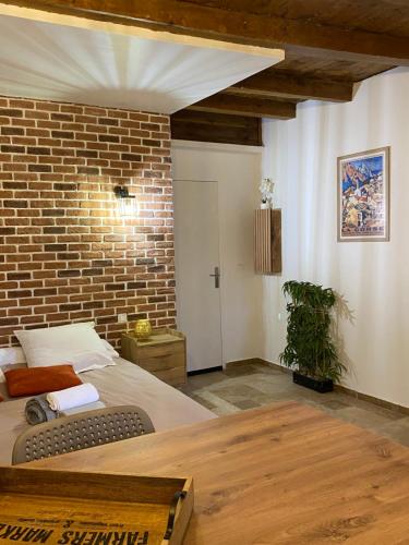 a bedroom with a bed and a brick wall at Très beau studio avec terrasse in Zonza