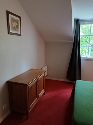 une chambre avec un lit, une commode et une fenêtre dans l'établissement Petite maison dans Résidence, à Monflanquin