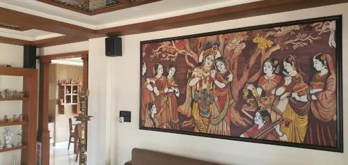 una gran pintura en la pared de una sala de estar en Unnimaya, en Kattakkada