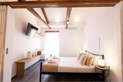 a bedroom with a bed and a tv on the wall at Ziv Boutique Apartments Town Square in Lefkada Town