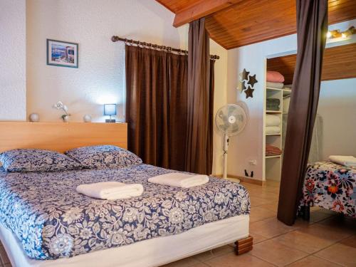 1 dormitorio con 1 cama con 2 almohadas y ventilador en Appartement de charme avec vue mer époustouflante, en Hyères