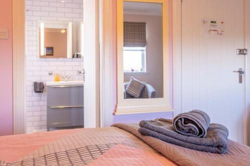 a bedroom with a bed with a mirror and a sink at Ard Buidhe B&B in Daliburgh