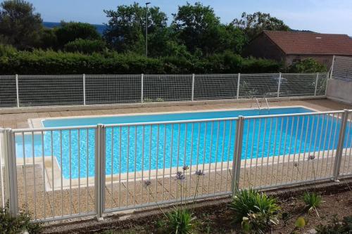 une piscine entourée d'une clôture dans l'établissement Appartement de charme avec vue mer époustouflante, à Hyères