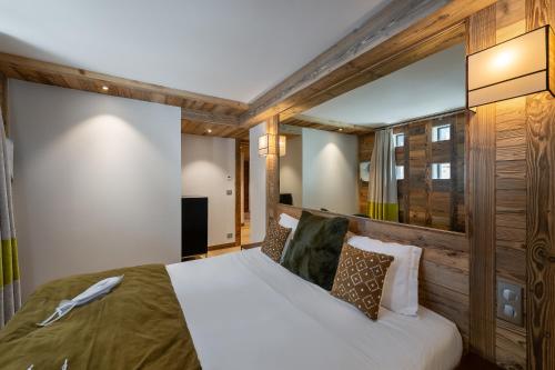 ein Schlafzimmer mit einem großen Bett in einem Zimmer in der Unterkunft Appartement Fusée - LES CHALETS COVAREL in Le Joseray