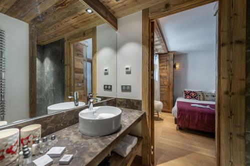 ein Badezimmer mit einem Waschbecken und einem großen Spiegel in der Unterkunft Appartement Fusée - LES CHALETS COVAREL in Le Joseray