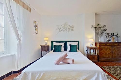 a bedroom with a large white bed with blue pillows at Les 2 Drôles d'Oiseaux in Luc-sur-Orbieu