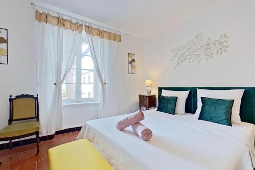 a bedroom with two beds and a yellow chair at Les 2 Drôles d'Oiseaux in Luc-sur-Orbieu