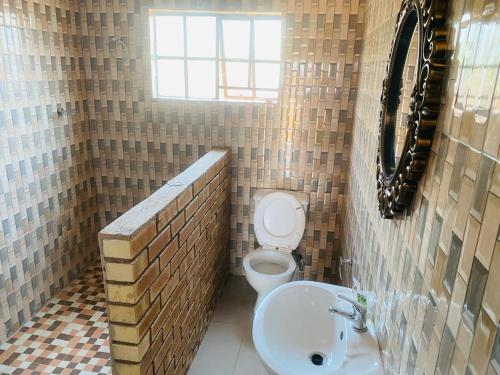 La salle de bains est pourvue de toilettes et d'un lavabo. dans l'établissement Lormasol Mews Guesthouse, à Serowe
