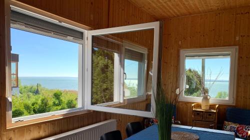 a room with two windows and a table with a view at Villa Nova Badacsony in Badacsonytomaj