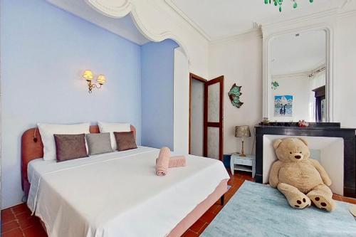 a bedroom with two beds and a teddy bear at Les 2 Drôles d'Oiseaux in Luc-sur-Orbieu