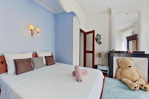 a bedroom with a teddy bear sitting next to a bed at Les 2 Drôles d'Oiseaux in Luc-sur-Orbieu