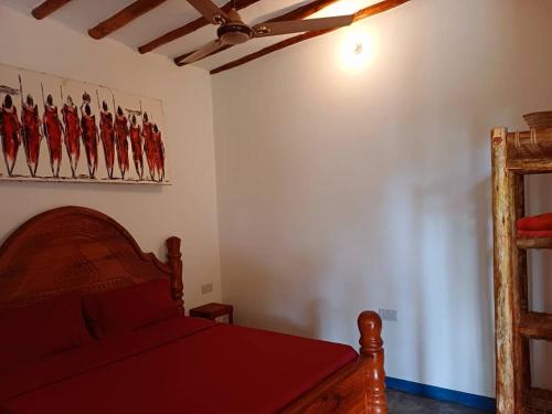 a bedroom with a bed with a red bedspread at Karibu Paradaizi in Michamvi