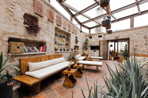 a living room with couches and tables in a stone wall at Millstone Cave Suites Hotel in Uchisar