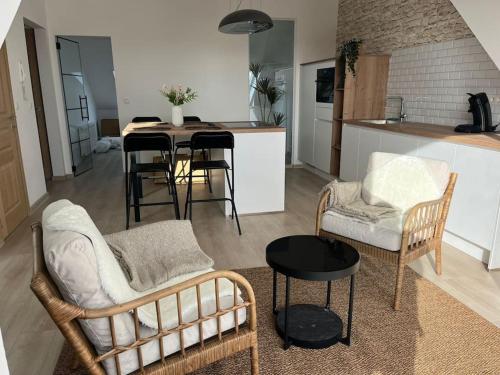 ein Wohnzimmer mit Stühlen und einem Tisch sowie eine Küche in der Unterkunft The Cosy House in Brüssel