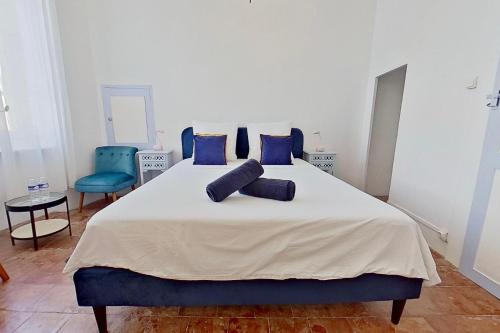 a bedroom with a large bed with blue pillows at Les 2 Drôles d'Oiseaux in Luc-sur-Orbieu