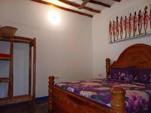 a bedroom with a wooden bed and a mirror at Karibu Paradaizi in Michamvi