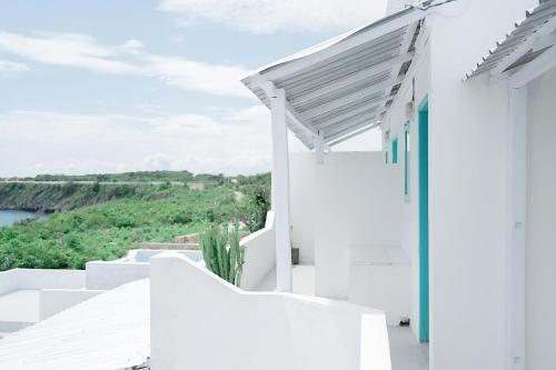 a white house with white stairs and a view at Woywoy Paradise in Bira