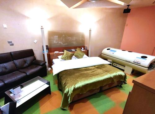 um quarto com uma cama e um sofá em Surfrider Adult Only em Sendai