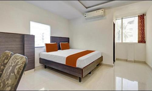 a bedroom with a bed and a chair in it at FabHotel The Cute in Bangalore